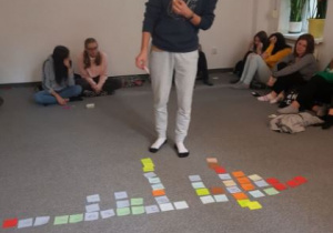 uczeń przygląda sie kolorowym kartkom z hasłami ekologicznymi